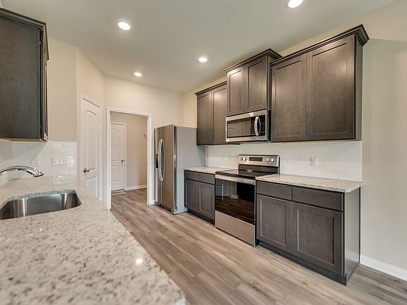 Gorgeous granite countertops and stunning wood cabinets are highlighted in the kitchen.