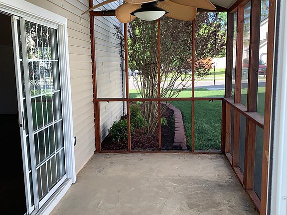 Outdoor screened in porch with ceiling fan.