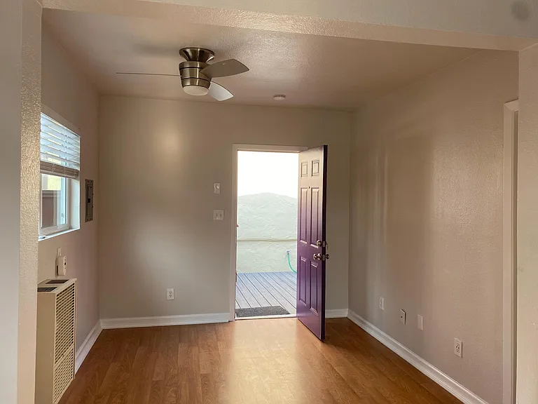 Looking from kitchen to side entrance through living room
