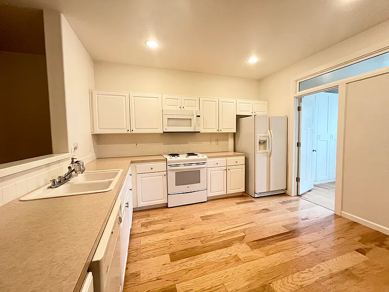 Kitchen with hardwoods, dishwasher, microwave, pantry.