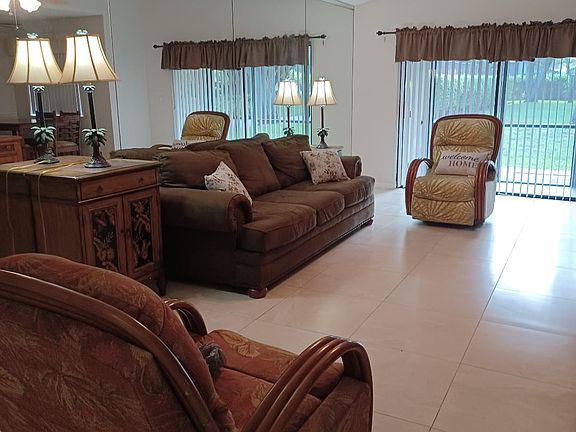 Furnished living room with 2 recliners, and room for a dining room table. There is also an entrance foyer.