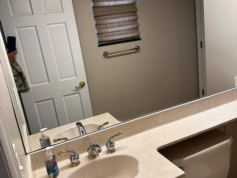 Master half bath vanity with long shelf extension, lights on a dimmer, and a designer window covering.
