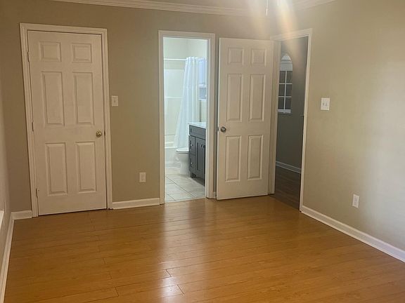 Primary bedroom featuring a ceiling fan and ensuite bathroom