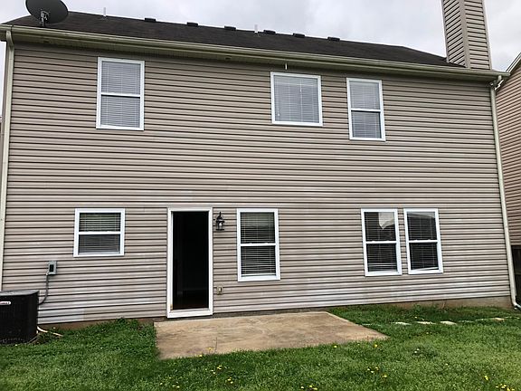 Back of house with back concrete patio pad.