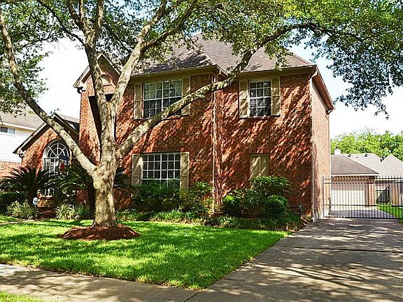 This beautiful home features  a remote retractable iron driveway gate and convenient sprinkler system.