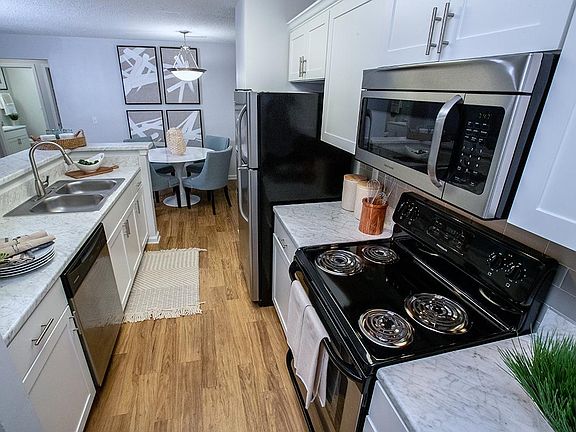 Select floor plans featuring galley style kitchens featuring white marble-style countertops and stainless steel appliances.