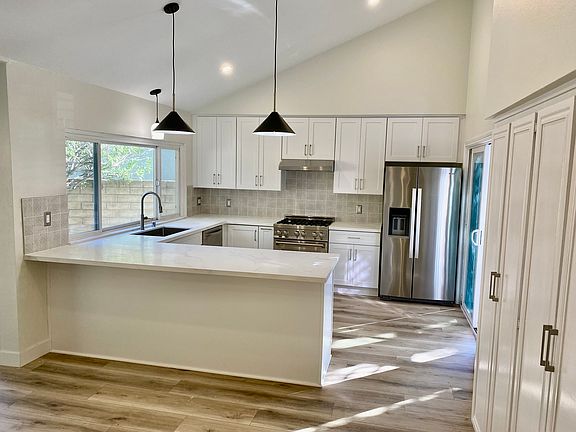 Modern entertainer's kitchen with quartz countertops, stainless appliances, and natural light.
