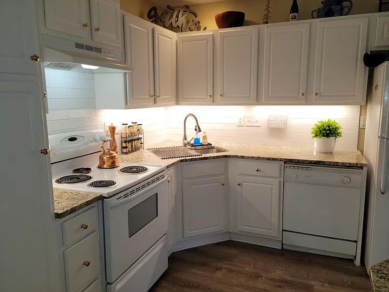 Kitchen with Granite countertops, subway tile backsplash, under cabinet lights, and new sink and faucet.