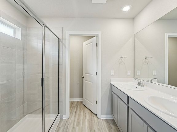 The primary bathroom includes dual-sinks and a walk-in shower.