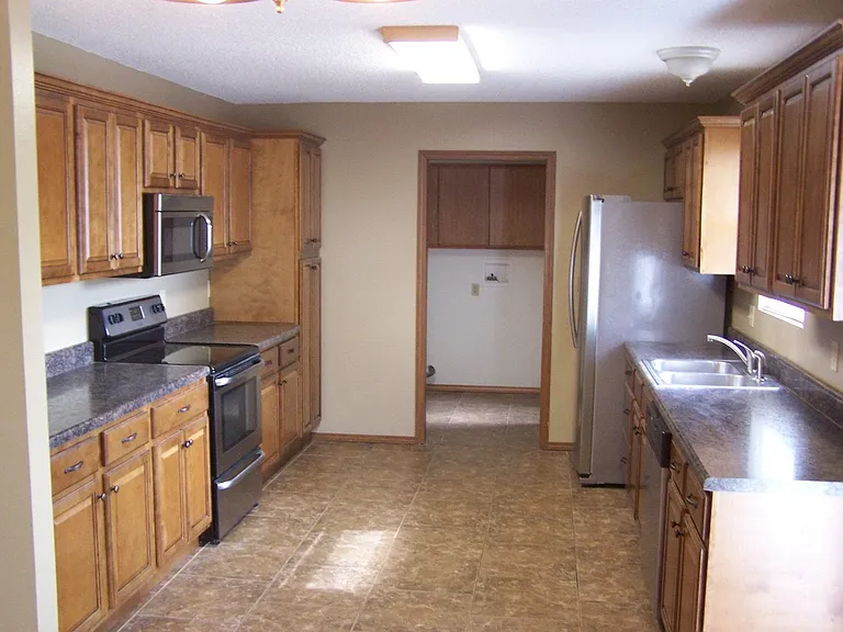 Kitchen from dining area. All new stainless steel appliances, cabinets, tile.
