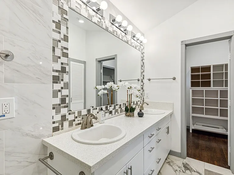 Dual vanity with white cabinetry and brushed nickel hardware, quartz countertops, and integrated sinks