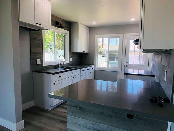 Kitchen with breakfast bar and exterior door to backyard