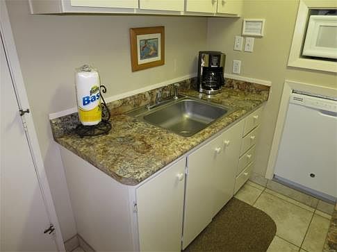 Kitchen sink is flanked with laminate counter tops in a stone print