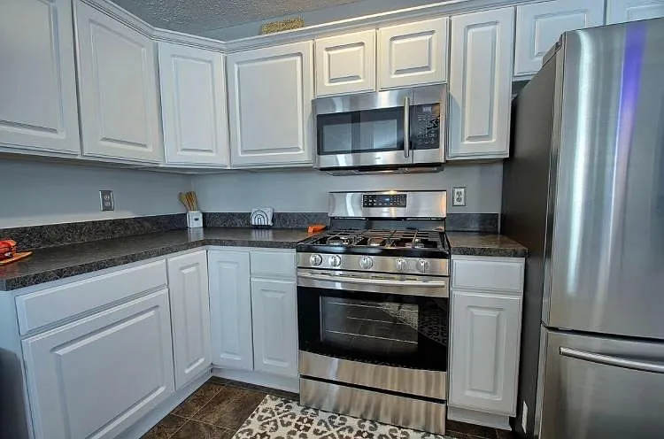 Gas range, stainless steel oven and microwave, and huge double-door refrigerator with dual layered drawer freezer. Plenty of counter space and storage in cabinets.