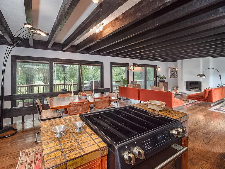 Gourmet kitchen with stainless steel appliances overlooking living room and golf course