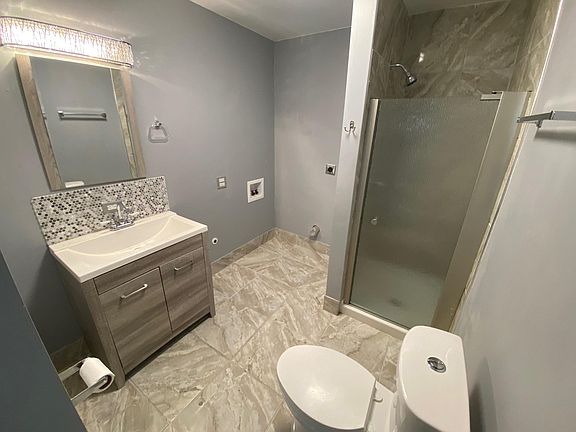 Large bathroom with shower and laundry hook-up area.