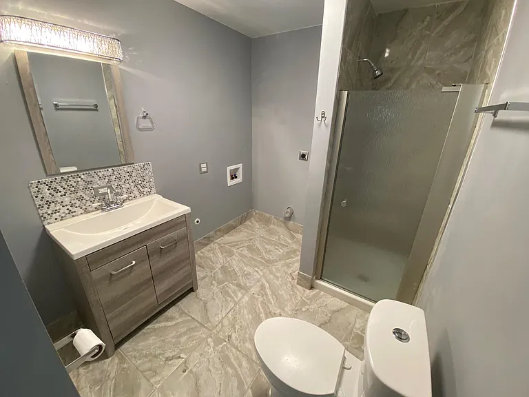 Large bathroom with shower and laundry hook-up area.