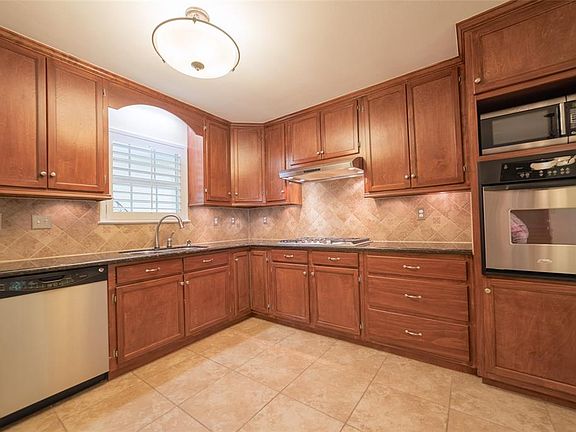Completely remodeled kitchen with Stainless Steel appliances. Rich stained custom cabinets that go all the way up to the ceiling with pull out shelves and "Lazy-Susan" feature.