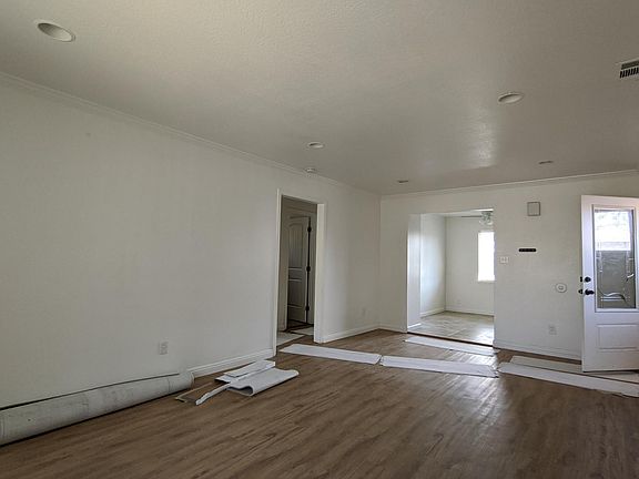 Living room. Front door on right. Dining room / kitchen in back. Bedrooms and bathroom on left. Pardon the work in progress. New flooring in living room, bedrooms, and hallways. New paint throughout.