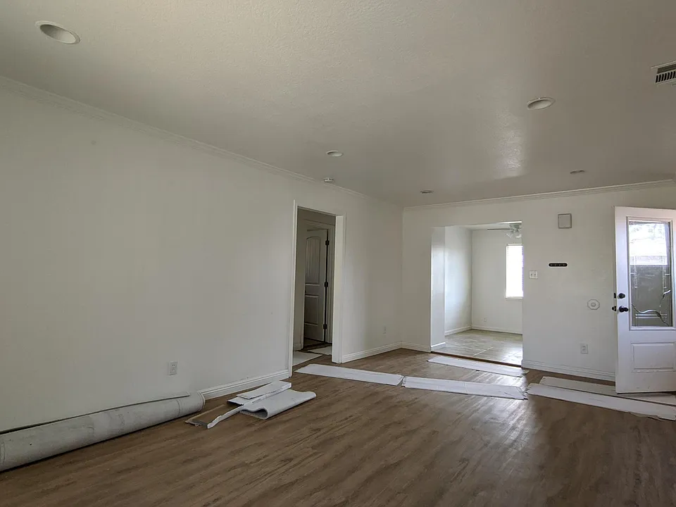 Living room. Front door on right. Dining room / kitchen in back. Bedrooms and bathroom on left. Pardon the work in progress. New flooring in living room, bedrooms, and hallways. New paint throughout.
