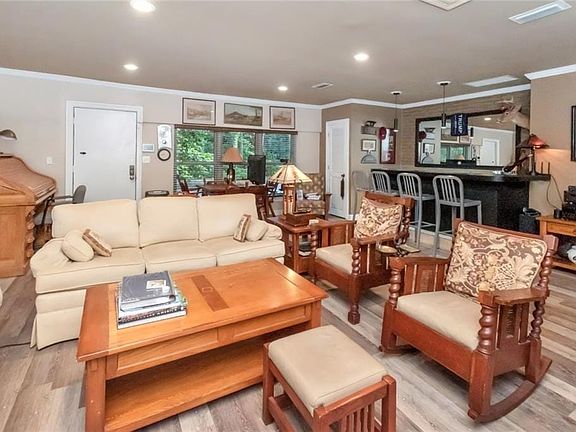 Living room with light wood-style flooring, visible vents, recessed lighting, and ornamental molding