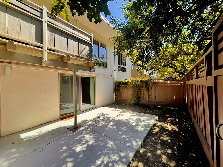 A townhouse patio. Many residents garden around the edges of their patio, or set up tables for outdoor dining and relaxing.