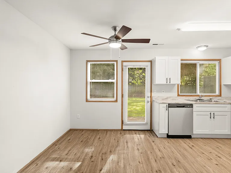 Light-filled kitchen and dining space with modern finishes, backyard access, and wood-style flooring. Light-filled kitchen and dining space with modern finishes, backyard access, and wood-style flooring.