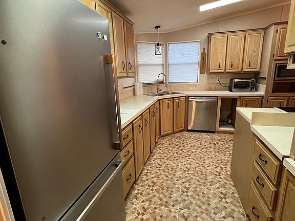 large tiled kitchen with new stainless steel appliances including fridge withh ice maker, and sink with garbage disposal.