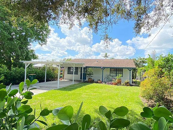 Front yard with carport and long drive way that is enclosed by rolling fence. Property is fully fenced along entire perimeter.