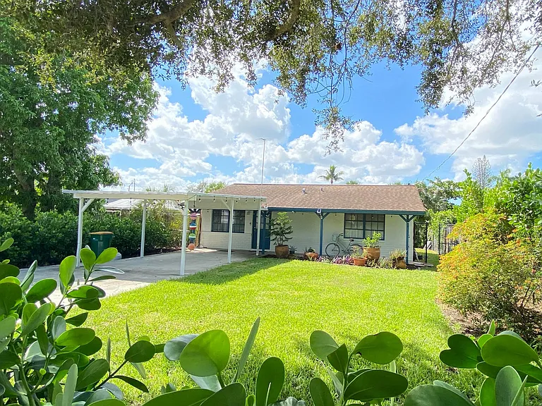 Front yard with carport and long drive way that is enclosed by rolling fence. Property is fully fenced along entire perimeter.