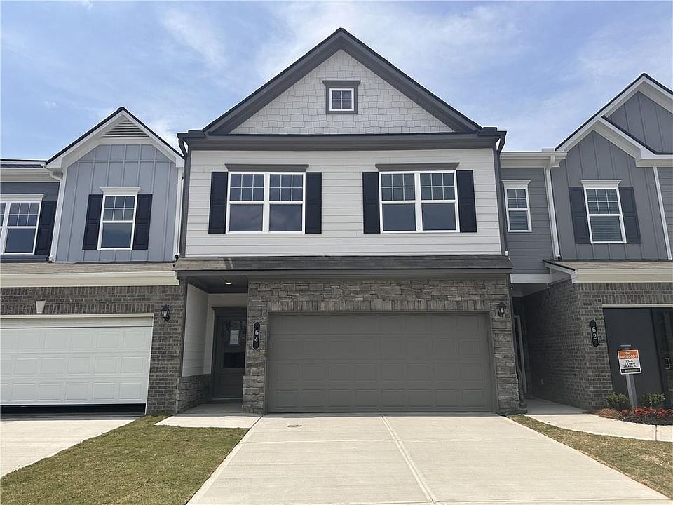 View of front facade featuring an attached garage, concrete driveway, board and batten siding, and