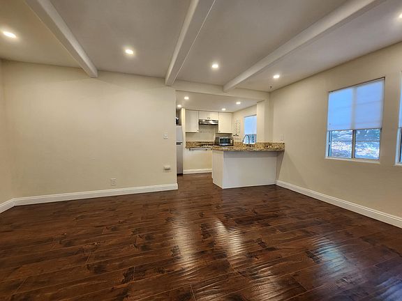 Well proportioned living room with easy access to the kitchen, bathroom, and custom window shades
