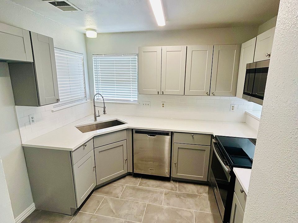 Stunning kitchen featuring new soft-close cabinets, stainless steel appliances, a farmhouse single-basin sink, modern faucet, and luxurious Carrara Quartz countertops. A perfect space for cooking and entertaining.