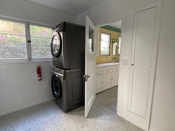 Large laundry room with new washer/dryer, walk-in pantry, built-in ironing board closet, and back door to stairs to carport