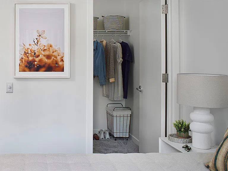 Spacious apartment bedroom with large closet and polished concrete flooring.