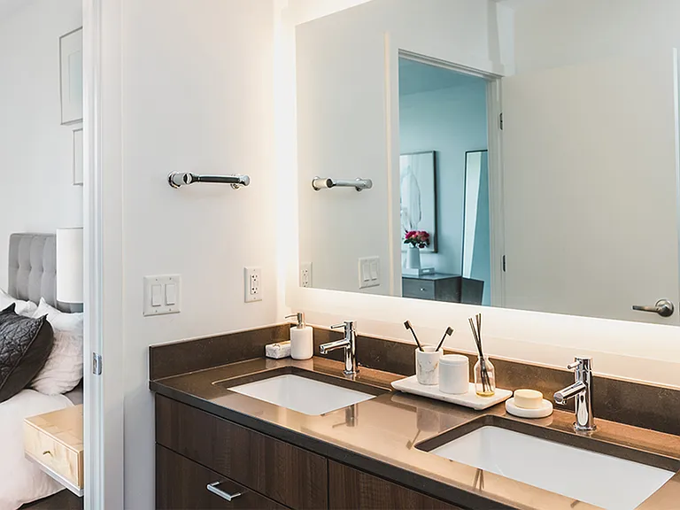 Dual vanities with quartz countertops and LED backlit mirror