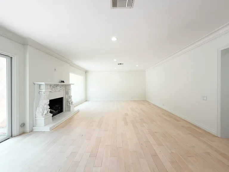 Sunlit living space with sliding glass doors and a fireplace creates seamless indoor-outdoor flow in this Beverly Hills luxury rental at 1094 Garden Lane, a 90210 home for rent.