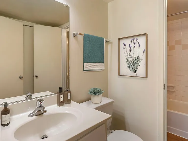 Renovated Woods I bath with white cabinetry, white countertops, and hard surface flooring