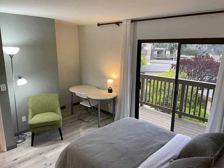 Second bedroom with writing desk, chair and adjoining deck