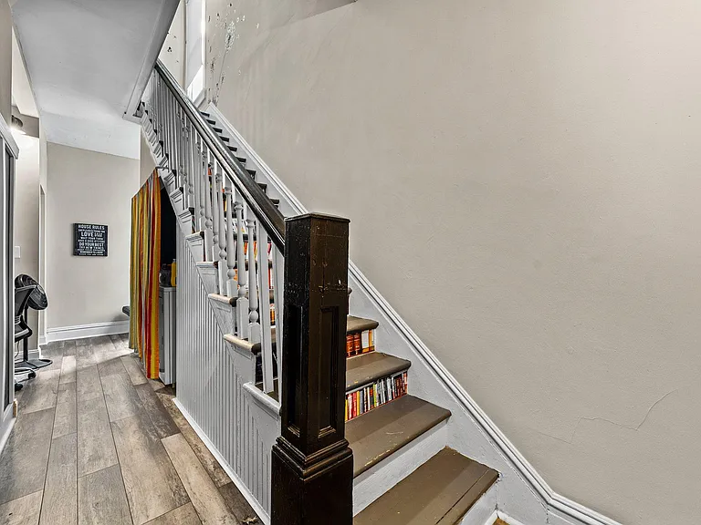 Washer and drier are nestled under the staircase, across from a communal work nook and reading window.