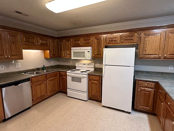 The kitchen includes a refrigerator with an ice maker, disposal, stove, microwave, and a new dishwasher, along with ample cabinet space for storage.