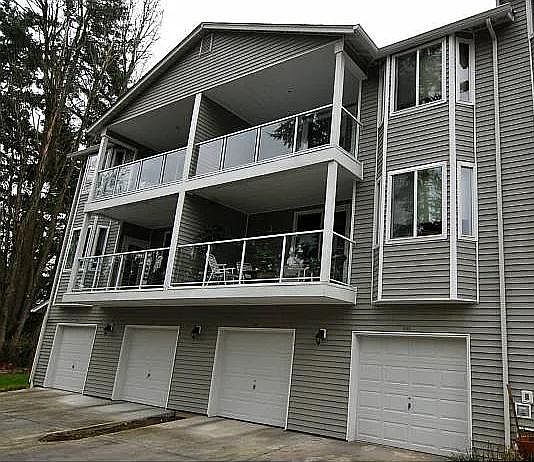 Garage entrance with back stairs to 2nd floor unit. Garage is 4th from end. Balcony is upper right. Primary bedroom is upper right bay window.