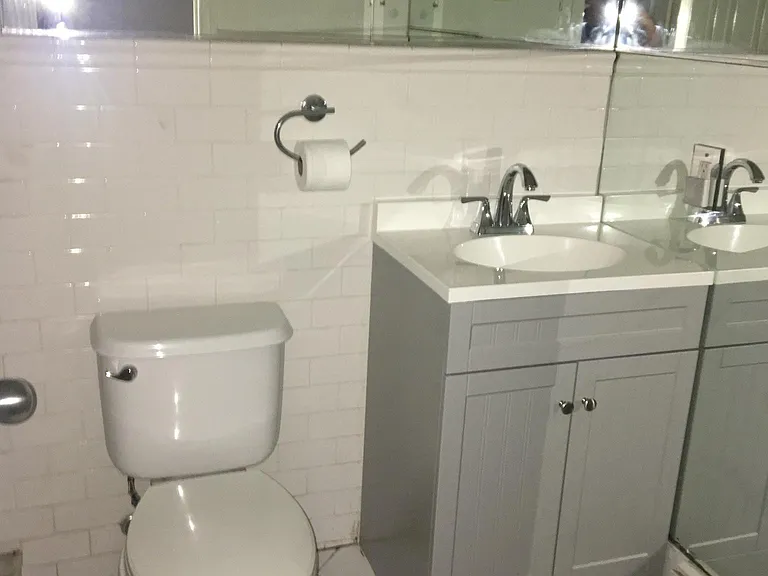bathroom with subway tiles and stall shower and mirror walls