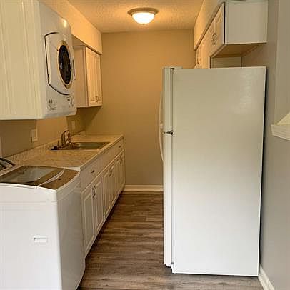 Galley kitchen with fridge, oven & microwave. Compact washer and dryer.