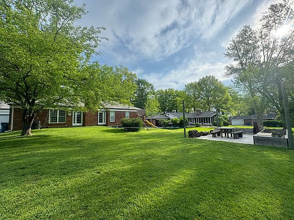 Level backyard with patio and raised bed garden. Overhead utilities relocated underground for unobstructed sky.
