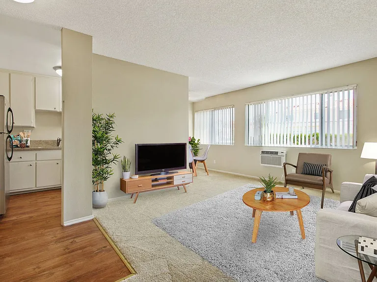 Living room with carpeted floors and Kitchen area with wood inspired floors