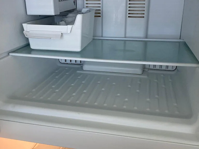 Ice maker in freezer section.