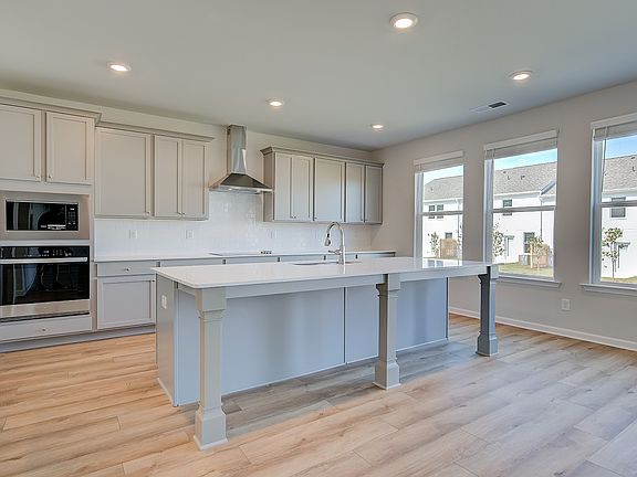 Open Ridgewood kitchen with bright modern features and oversized island with seating at Bowers Farm.