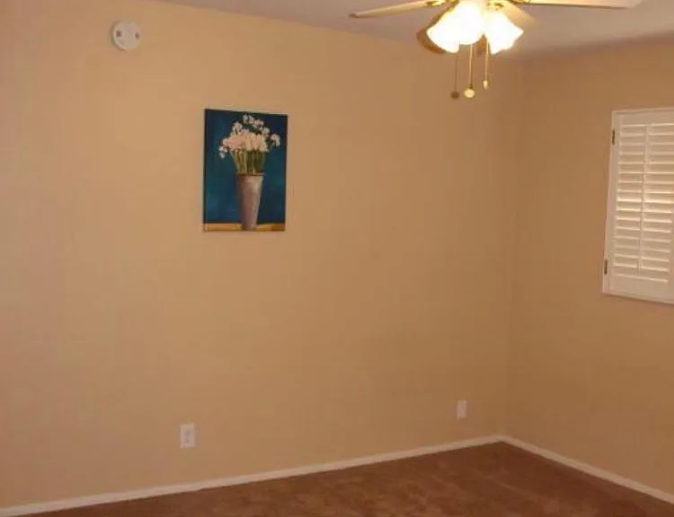 bedroom 1 with shutters and ceiling fan