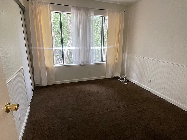 second bedroom. freshly painted and washed carpet. has beautiful views of nature and closet space.